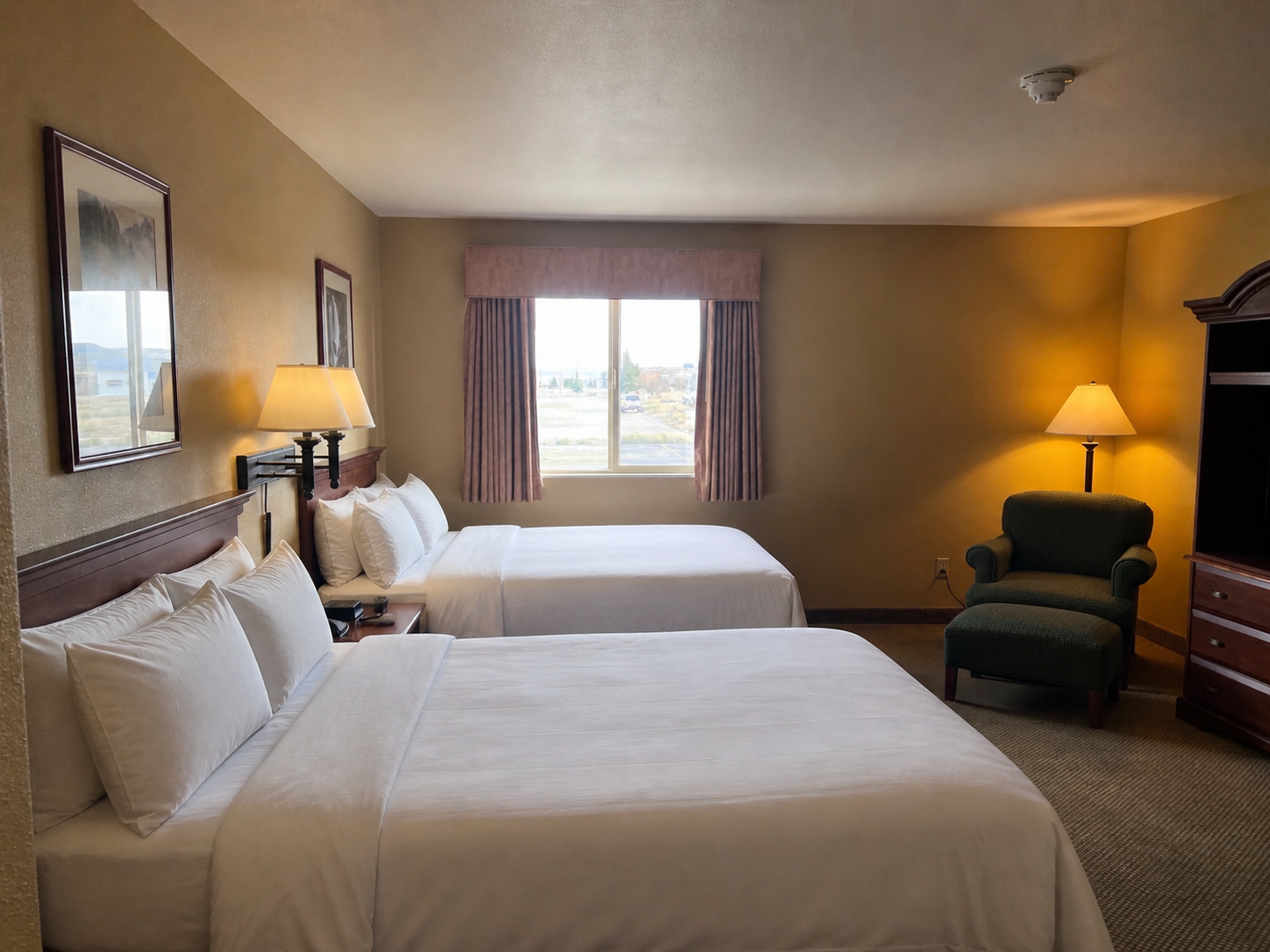 Deluxe 2 Double room with two double beds, sitting chair, and mountain-view window